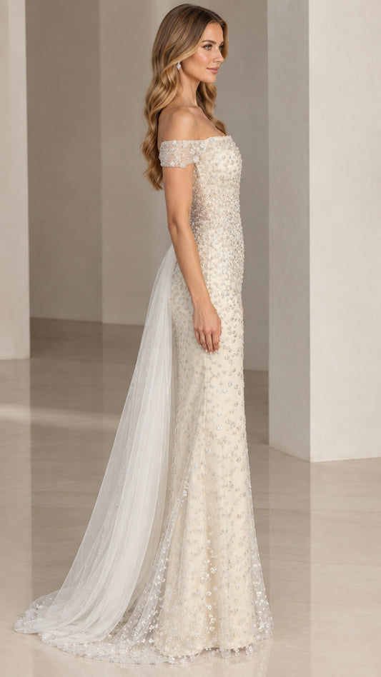 Side profile view of ivory beaded formal gown showing attached side tulle overskirt